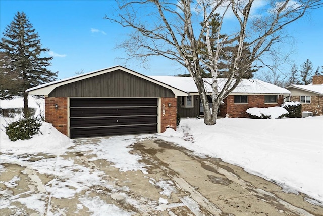 single story home featuring brick siding, an attached garage, and driveway