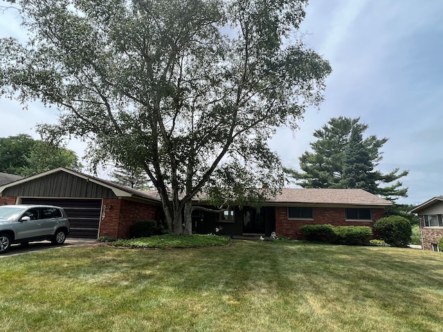 single story home featuring a garage, brick siding, and a front yard