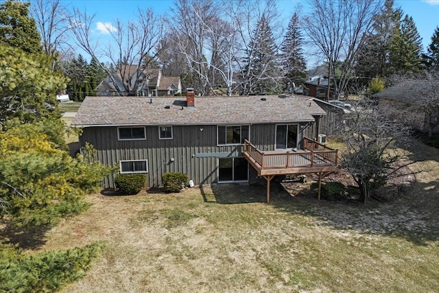 back of property featuring a lawn, board and batten siding, a deck, and a chimney