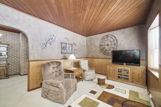 living room featuring wainscoting, wood ceiling, and wooden walls