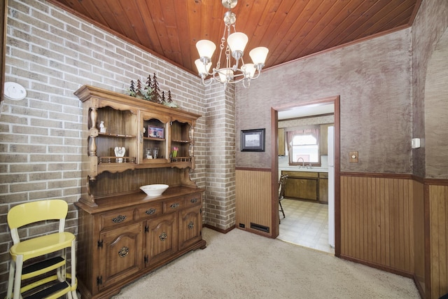 interior space featuring a chandelier, wooden ceiling, wooden walls, wainscoting, and light floors