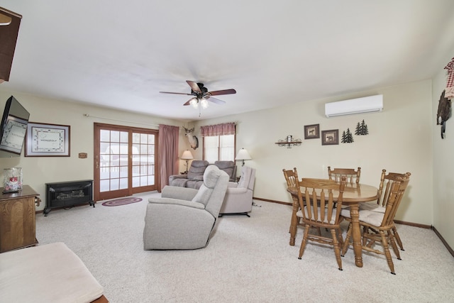 living area with baseboards, ceiling fan, a wall mounted air conditioner, and light colored carpet