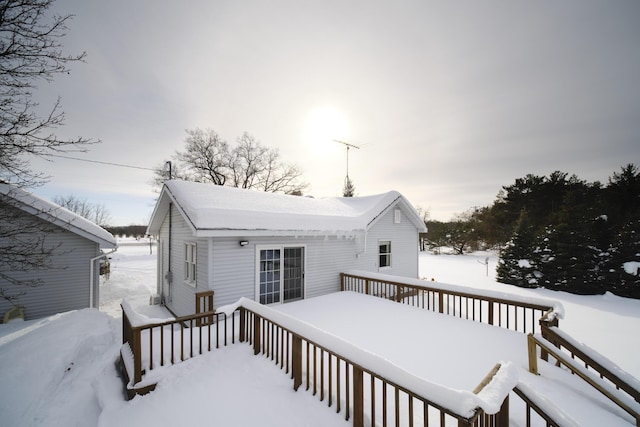 snow covered house with a wooden deck