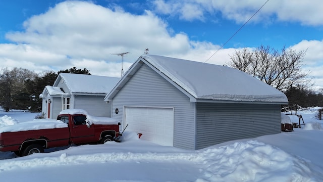 snow covered property featuring a garage