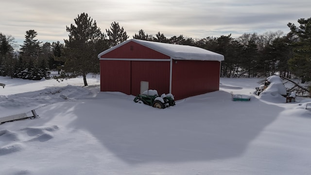 snow covered structure featuring an outbuilding