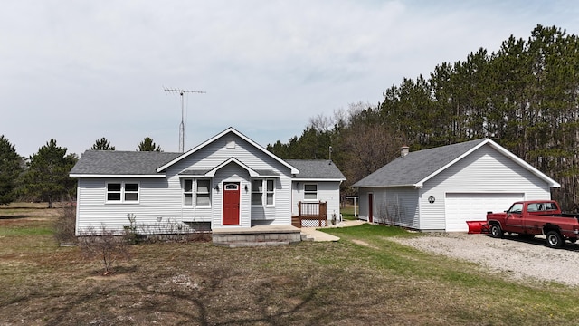 view of front facade with a detached garage, roof with shingles, an outdoor structure, and a front yard