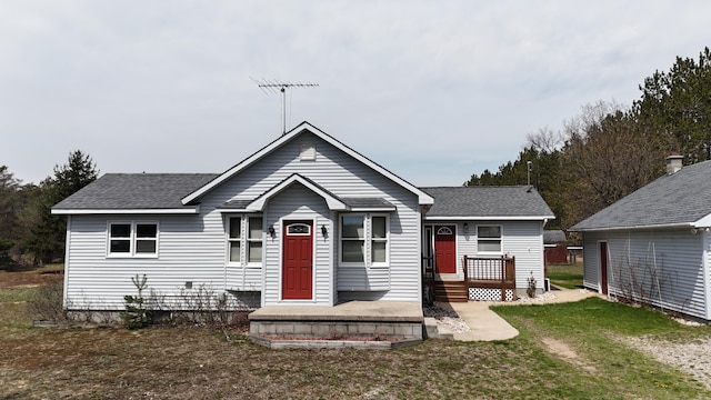 bungalow-style house with a shingled roof and a front lawn