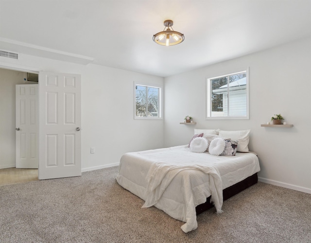 bedroom with carpet floors, visible vents, and baseboards