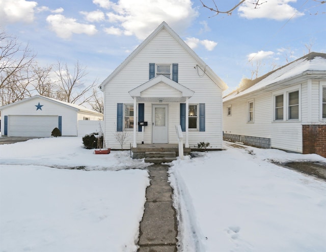 bungalow-style home with a garage and an outbuilding