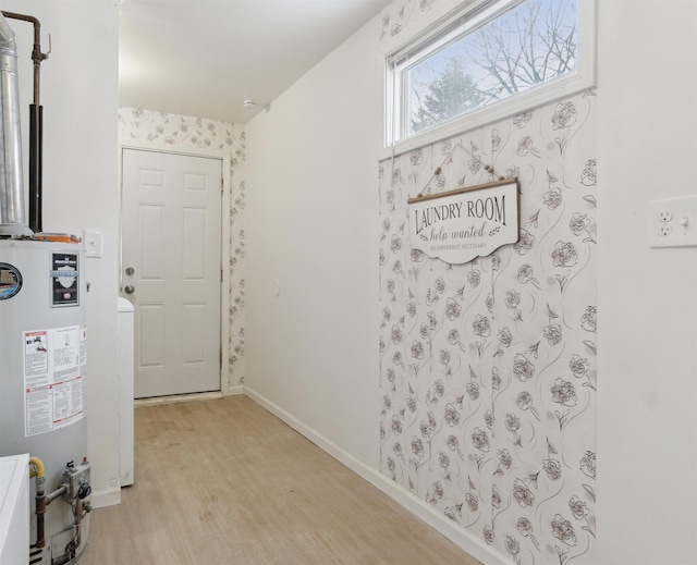 entryway featuring light wood-style floors, gas water heater, and baseboards