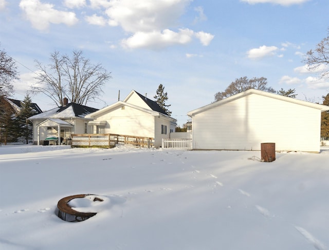 snow covered rear of property featuring a deck