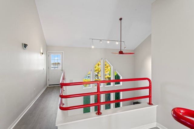 recreation room with rail lighting, dark wood finished floors, and baseboards