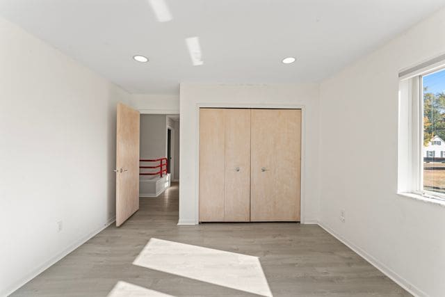 unfurnished bedroom featuring recessed lighting, baseboards, and light wood finished floors