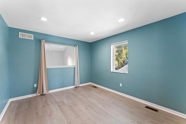 spare room with recessed lighting, baseboards, visible vents, and light wood finished floors