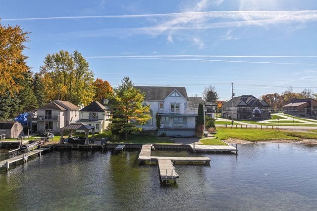 dock area featuring a lawn, a water view, and a residential view