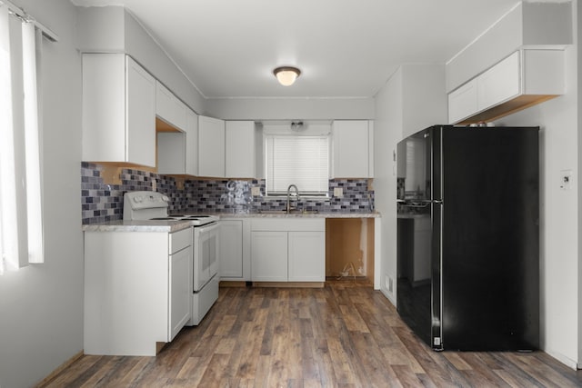 kitchen featuring a sink, white cabinets, light countertops, freestanding refrigerator, and white range with electric cooktop