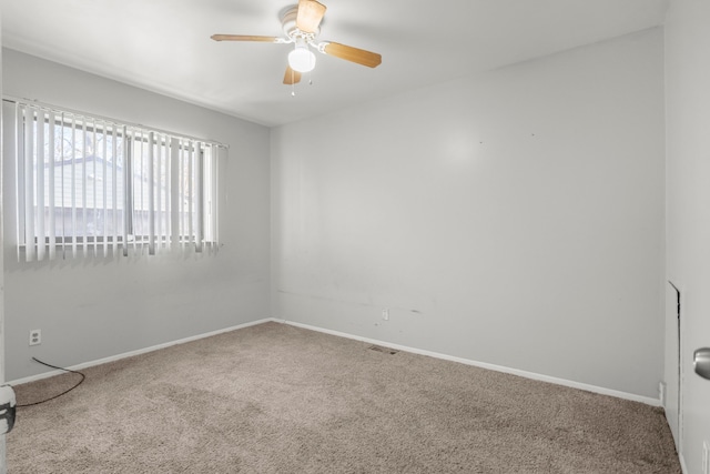 carpeted empty room featuring ceiling fan and baseboards