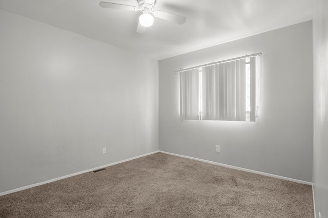 empty room featuring baseboards, carpet, visible vents, and a ceiling fan