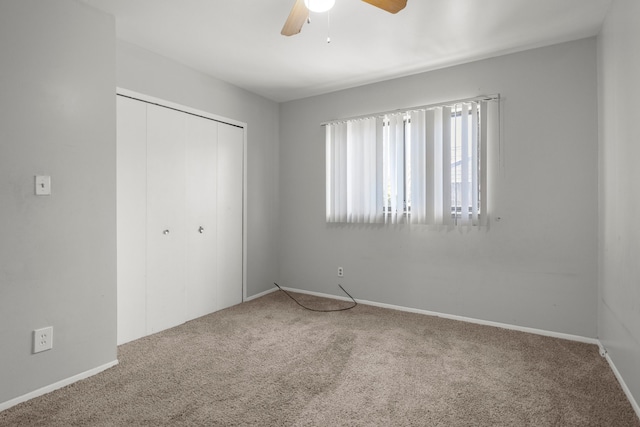 unfurnished bedroom featuring ceiling fan, a closet, carpet, and baseboards