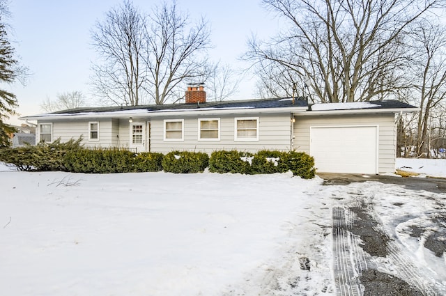 ranch-style house with a garage and a chimney