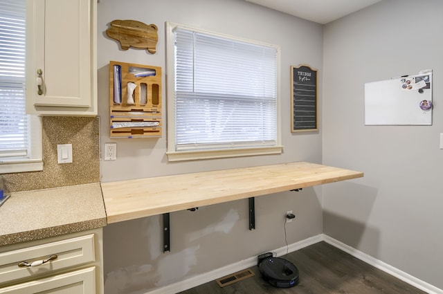 interior space with dark wood-style flooring, visible vents, and baseboards