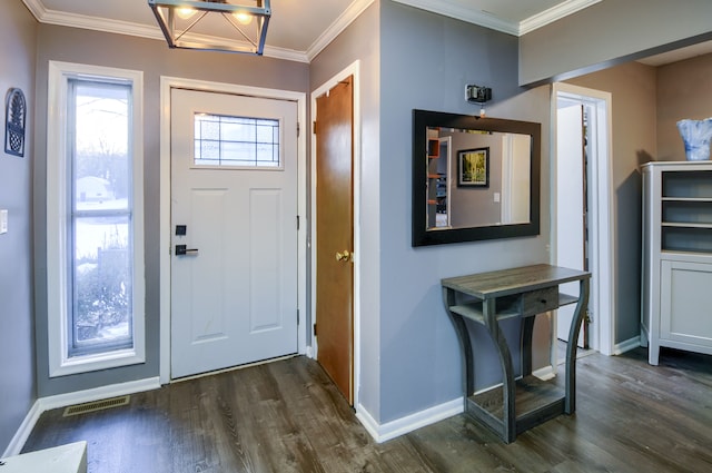 entryway with dark wood finished floors, visible vents, crown molding, and baseboards