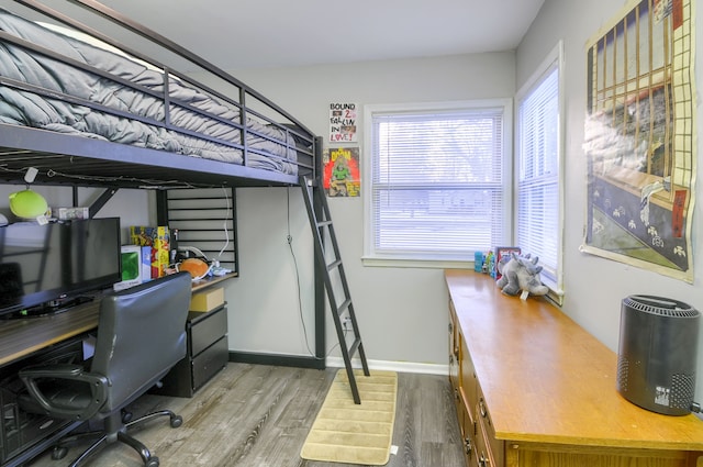 bedroom with baseboards and wood finished floors