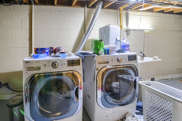 laundry room featuring laundry area, separate washer and dryer, and a sink