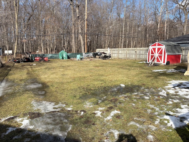 view of yard with a storage shed, fence, and an outbuilding