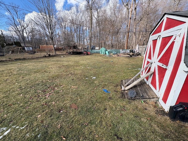 view of yard featuring a shed, an outdoor structure, and fence