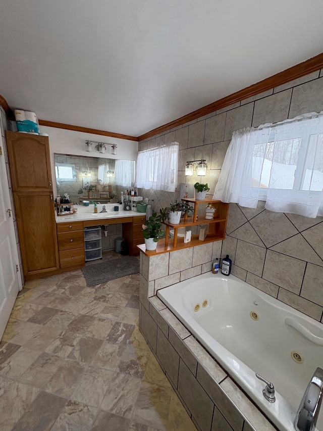 bathroom with ornamental molding, a tub with jets, vanity, and tile walls