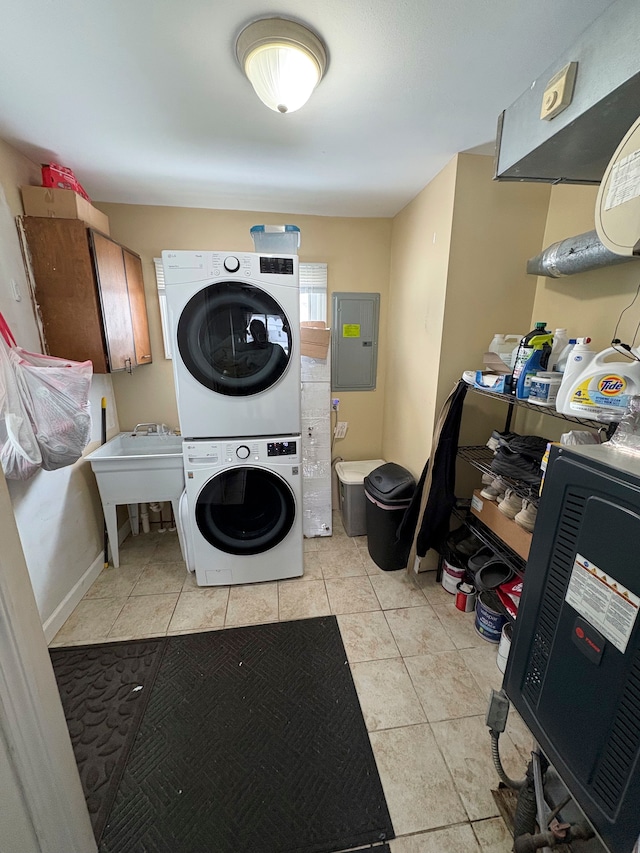 laundry room featuring light tile patterned floors, laundry area, a sink, electric panel, and stacked washer and clothes dryer