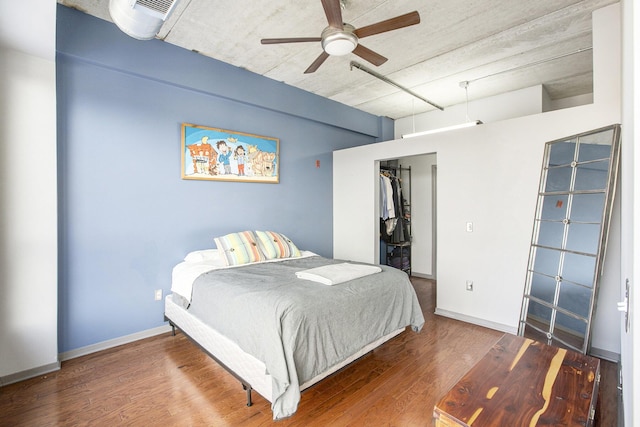 bedroom featuring ceiling fan, a closet, wood finished floors, and baseboards