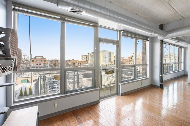 unfurnished sunroom featuring visible vents and a city view