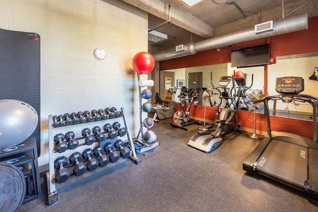 gym featuring concrete block wall and visible vents