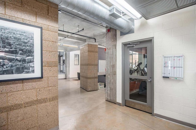hall with concrete block wall and concrete floors