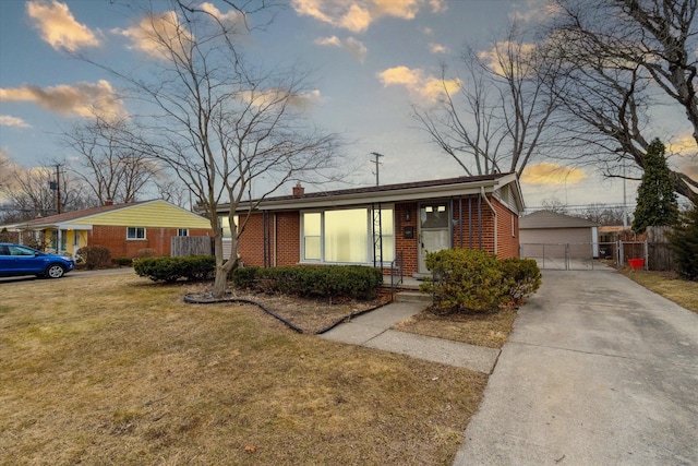 view of front of home featuring brick siding, an outdoor structure, a front yard, and fence