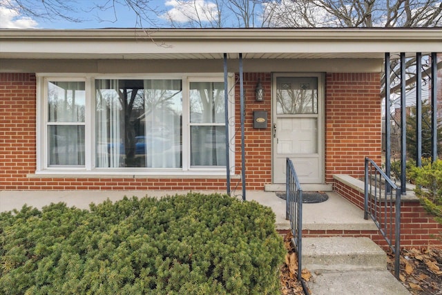 entrance to property featuring brick siding