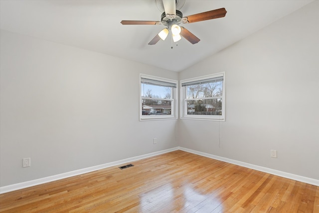 unfurnished room featuring vaulted ceiling, light wood-style flooring, visible vents, and baseboards