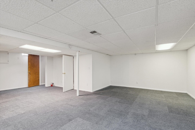 finished below grade area featuring carpet flooring, baseboards, a paneled ceiling, and visible vents