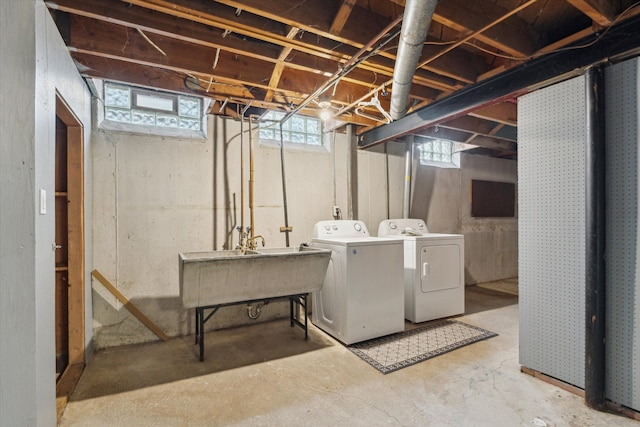 below grade area with a sink and washer and clothes dryer