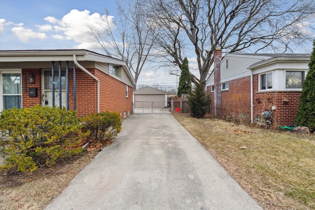 view of home's exterior with an outbuilding, brick siding, and a detached garage