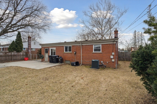 back of house featuring cooling unit, fence, a yard, a patio area, and brick siding