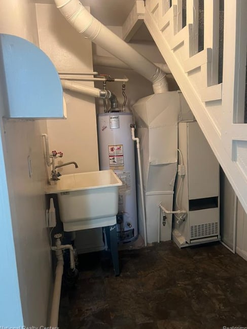 utility room featuring a sink and gas water heater