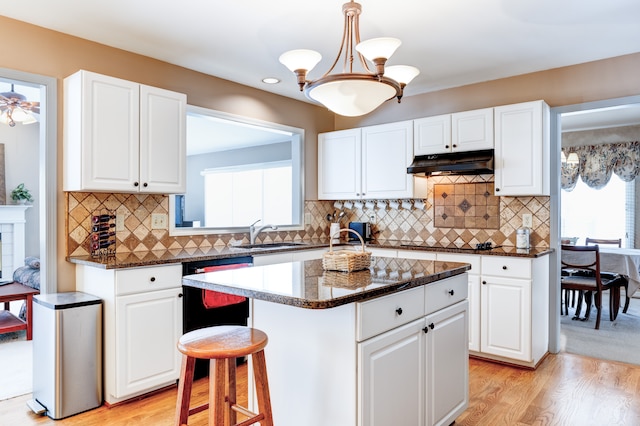 kitchen featuring a kitchen island, white cabinetry, and under cabinet range hood