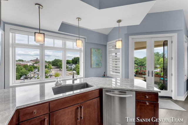 kitchen with pendant lighting, a sink, stainless steel dishwasher, and french doors