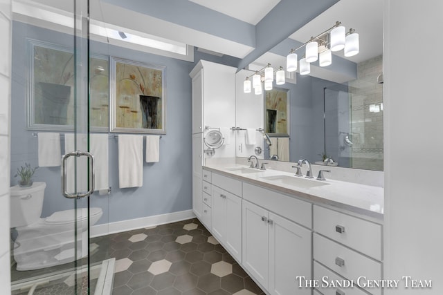 bathroom with toilet, a stall shower, and a sink