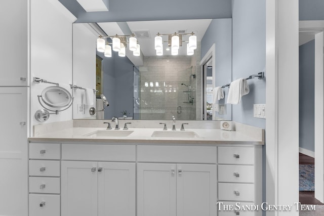 full bathroom featuring double vanity, a stall shower, visible vents, and a sink