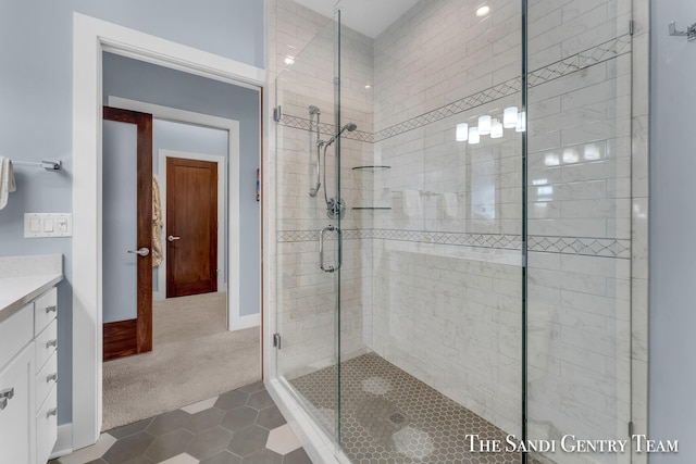 bathroom with a stall shower, tile patterned flooring, baseboards, and vanity