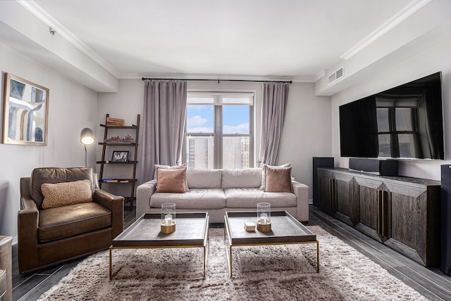 living area with wood finished floors, visible vents, and ornamental molding